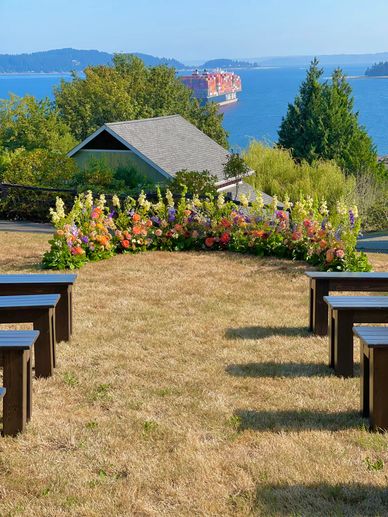 Colorful flowers arranged in an arch on the ground creating a meadow for wedding ceremony.