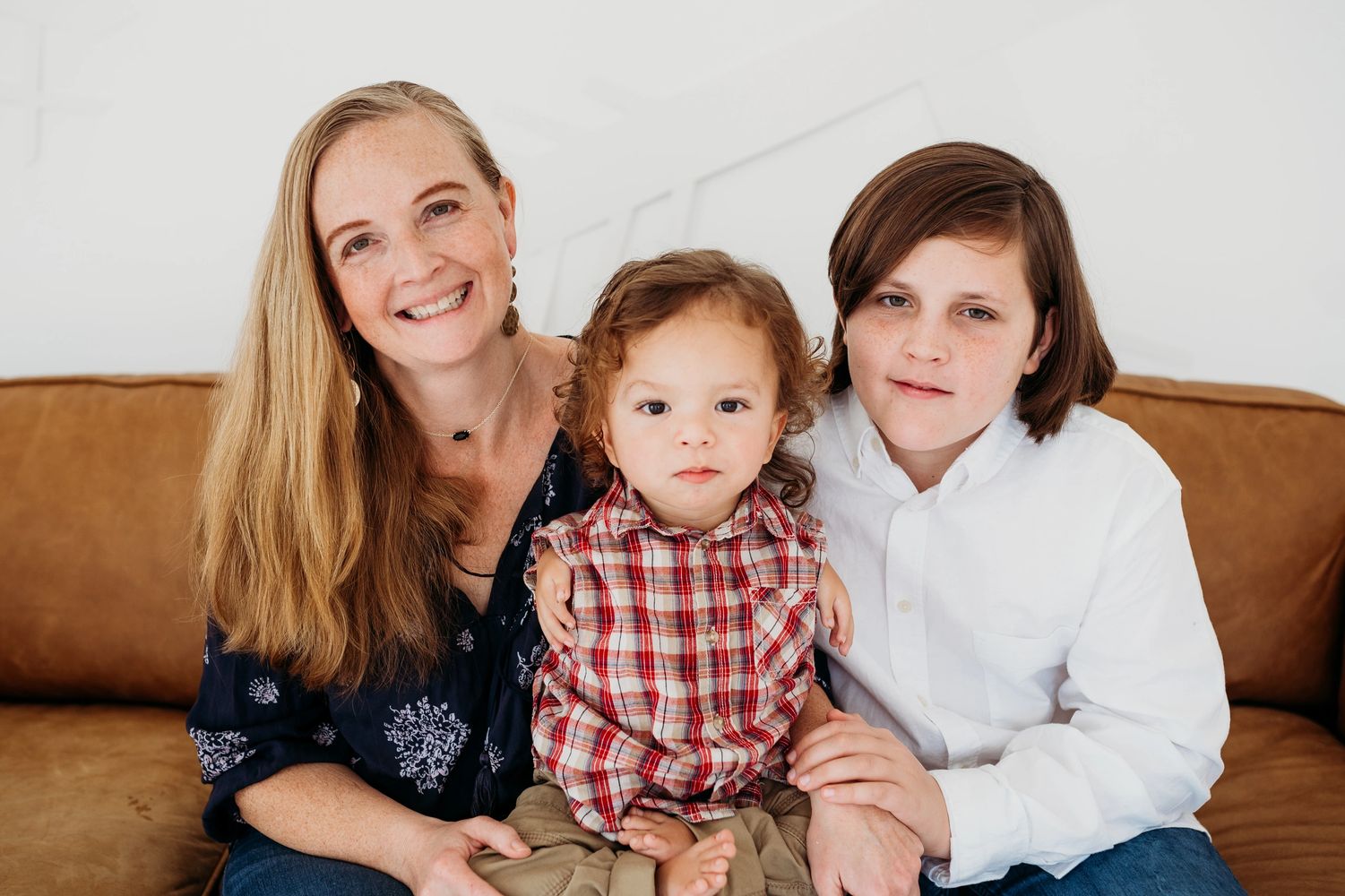Christina and her two boys sitting and smiling.