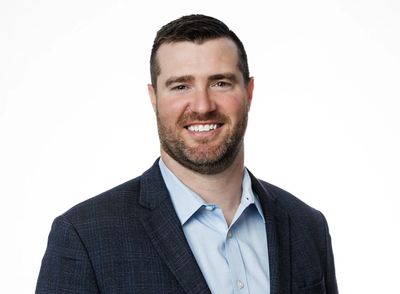 Smiling man in business attire against white background.
