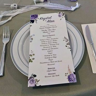Wedding place setting with wedding ceremony program on top of plate