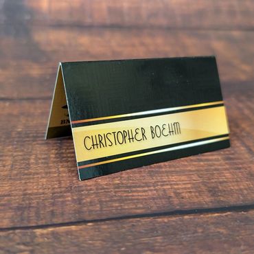 A black and gold fold-over business card