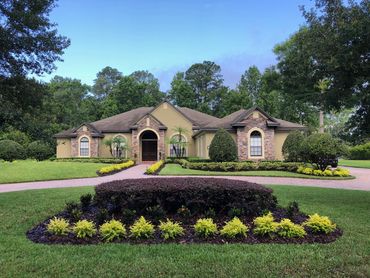 home with landscaping in front yard in various landscape beds