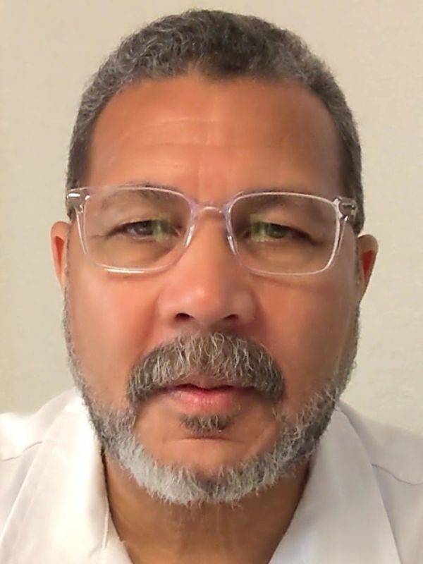 Middle-aged man with glasses and a salt-and-pepper beard wearing a white shirt.