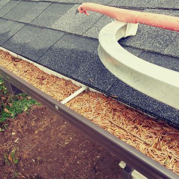 Gutters filled with pine needles that is in need of a gutter cleaning.