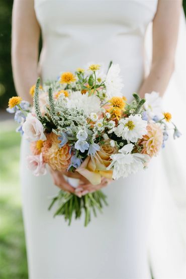 Bride bouquet in orange, peach, white, blue and light pink. 
