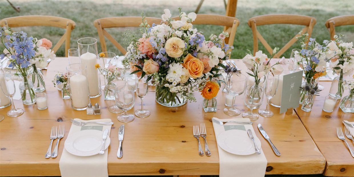 Flower arrangement with candles on a farmhouse table. Photo Credit: Hannah Baldwin Photography 