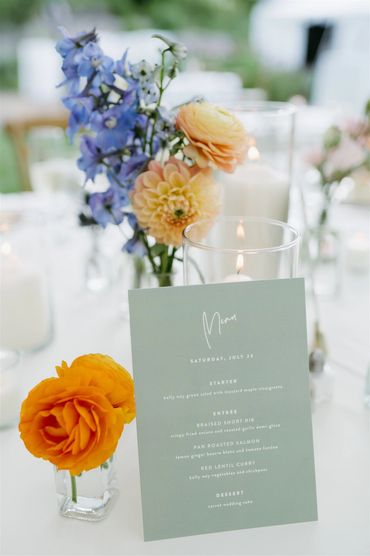 Orange and blue flowers designed in bud vases for a wedding designed by Twigs et fleurs. 