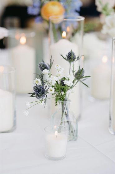 Candles and a simple bud vase iwth thistle and feverfew.