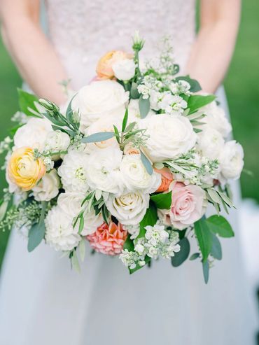 Classic bride bouquet with flowers in white and accents of peach, yellow, blush and coral. 