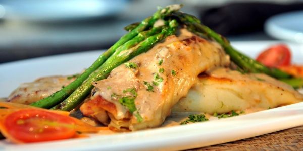 Grilled fish fillet topped with asparagus and sauce.