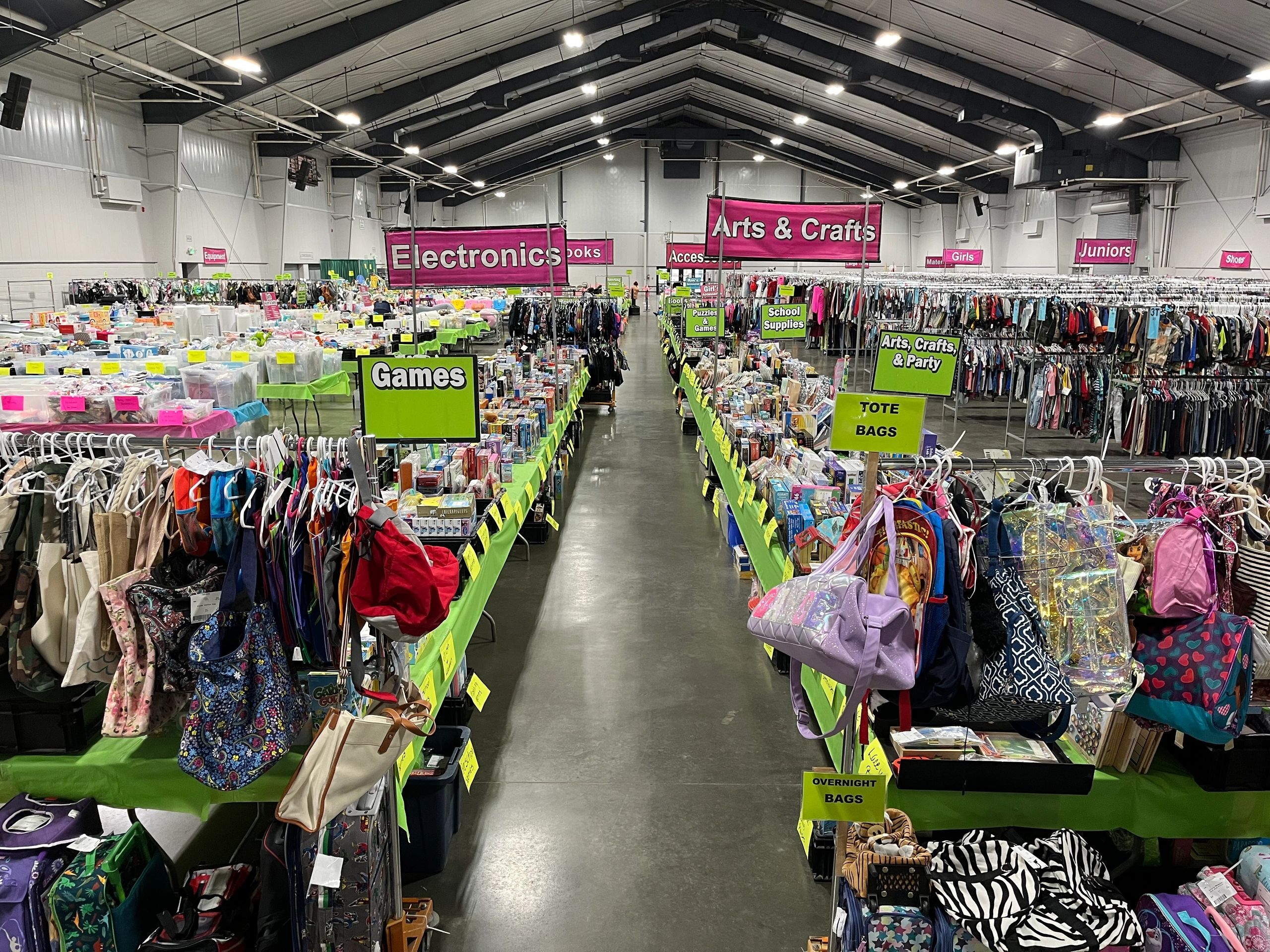 Large indoor market with various sections for clothes, games, crafts, and electronics.