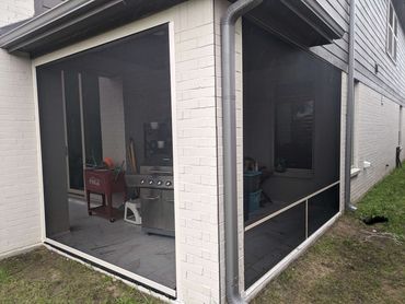 Motorized roll shade with a fixed screen enclosure.