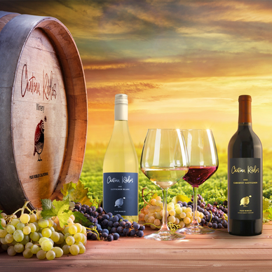 Wine bottles and glasses with a vineyard as a background