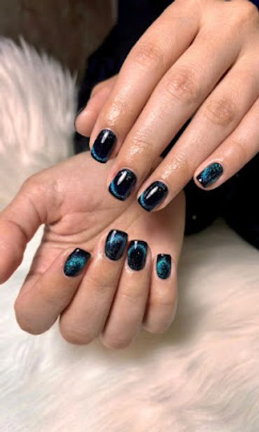 Modern short nail art with black polish and sparkling blue glitter details