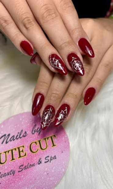 Stylish almond-shaped red nails with sparkling silver star details