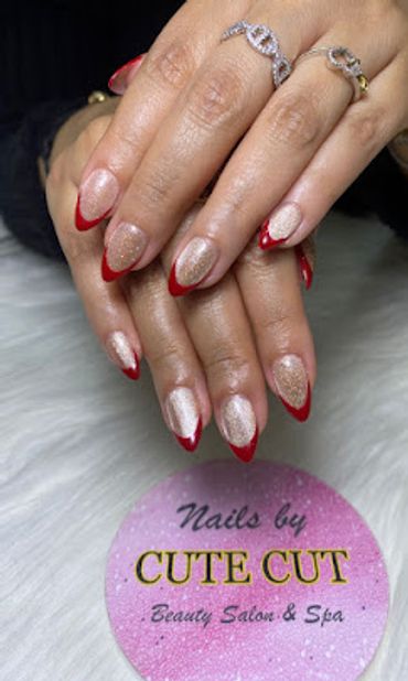 Trendy soft pink nails with stylish red tips and sparkling glitter accents