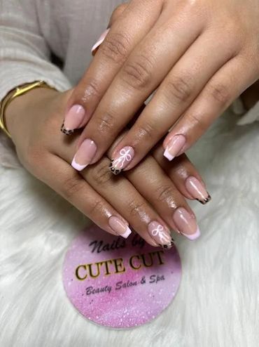 Elegant French manicure with leopard print and bow accents on nude almond-shaped nails