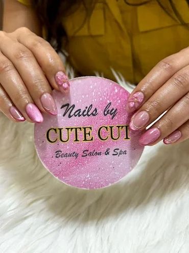 Trendy pink manicure with floral nail art and metallic detailing for stylish almond nails