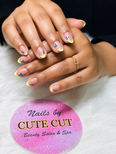 Yellow French tip nails with blue floral design — Cute Cut Beauty Salon & Spa, Zinj Bahrain