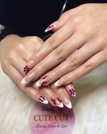 Hands with elegant floral and French tip nail art design.