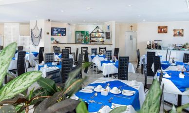 Empty restaurant with blue and white table settings.