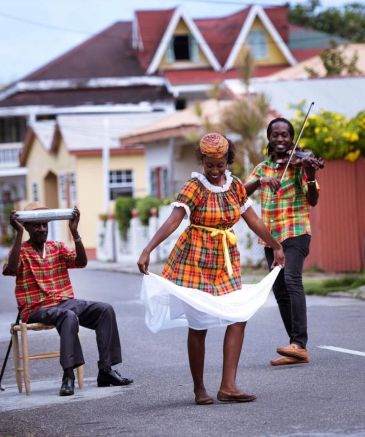 People in colorful plaid clothes enjoying music and dance outdoors.