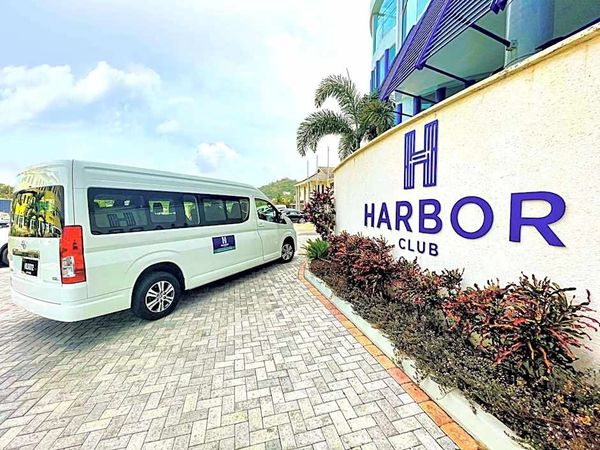 White van parked beside Harbor Club building.