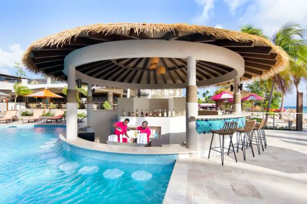 A tropical poolside bar with bartenders at work.