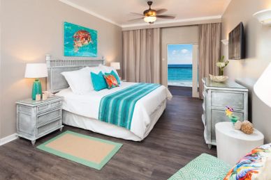 Bright bedroom with ocean view and turquoise accents.