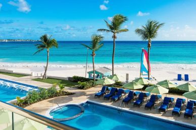 Beachfront resort with pool and palm trees.