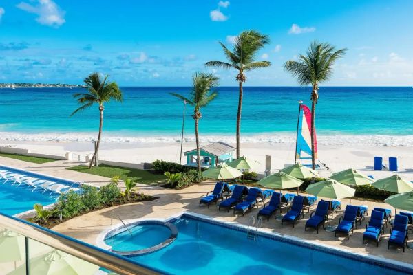 Beach resort with pools and palm trees.