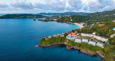 Coastal resort with lush greenery and clear blue water.