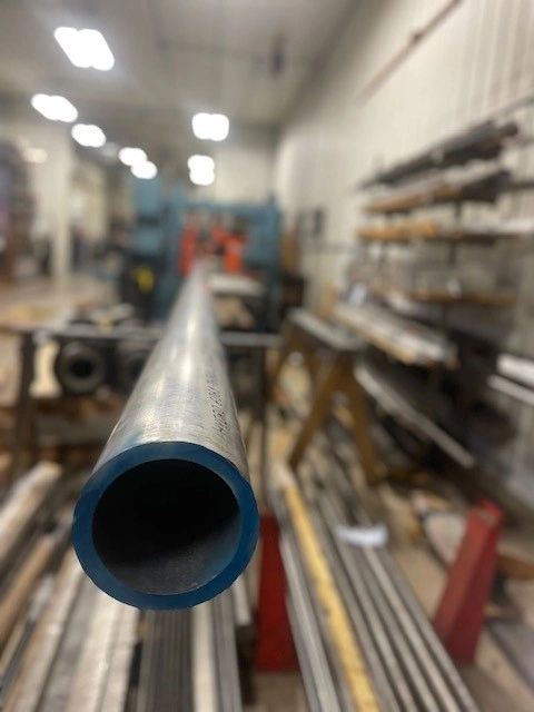 Metal tube on our CNC saw getting ready to be cut.