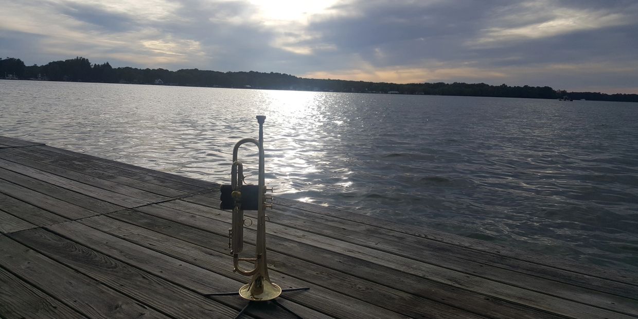 My Flip Oakes Wild Thing Trumpet on a pier overlooking a beautiful lake as the sun sets