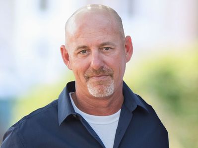 Owner, Mike Fennel in a blue button up shirt, goatee and no hair.