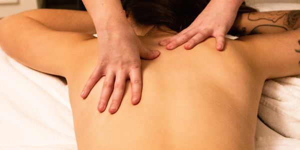 Therapist massaging a clients upper back