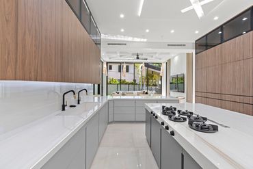 sleek, contemporary, warm kitchen. gas cooktop, stove