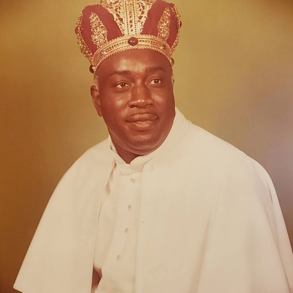 Portrait of Bishop R.J. Roff wearing a regal crown and white clergy robe.