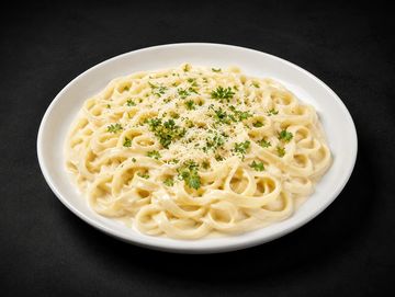 Plato de pasta Alfredo con perejil.