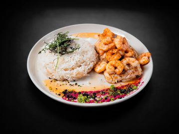 Plato con arroz y camarones sazonados.