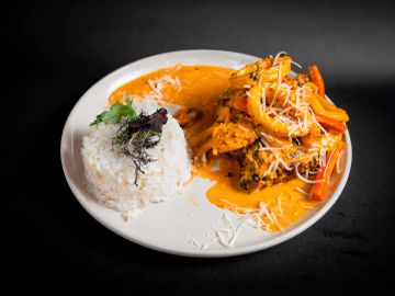 Plato de pescado con arroz y salsa cremosa.