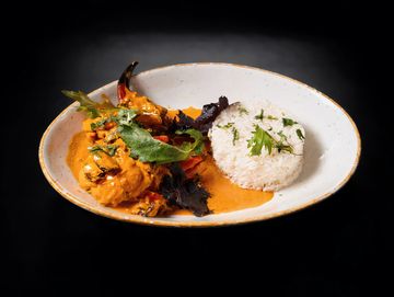 Plato con arroz blanco y salsa cremosa con hierbas.