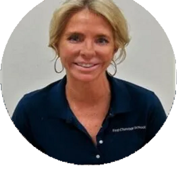 Woman smiling, wearing a navy polo shirt with a logo.