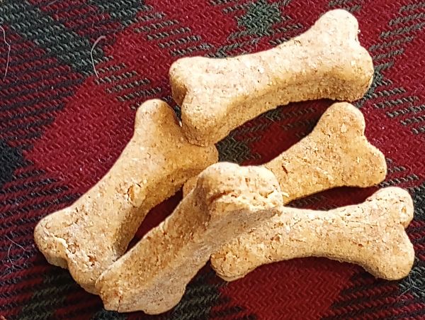 Bone-shaped dog treats on cozy plaid, handmade in Pennsylvania with real, gluten-free ingredients.