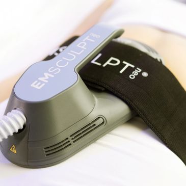 Close-up of an EMSCULPT device attached to a body with a black strap.