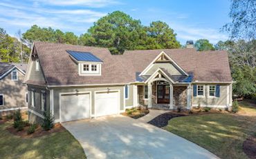 A modern single-story house with solar panels on the roof and a two-car garage.