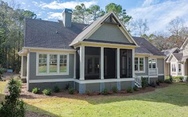 A modern single-story house with a screened porch and well-kept lawn.