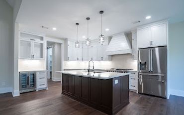 Modern kitchen with white cabinets and a dark wood island.