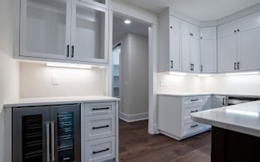 Modern kitchen with white cabinets and under-cabinet lighting.
