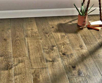 Wooden floor with a plant and books in the corner.